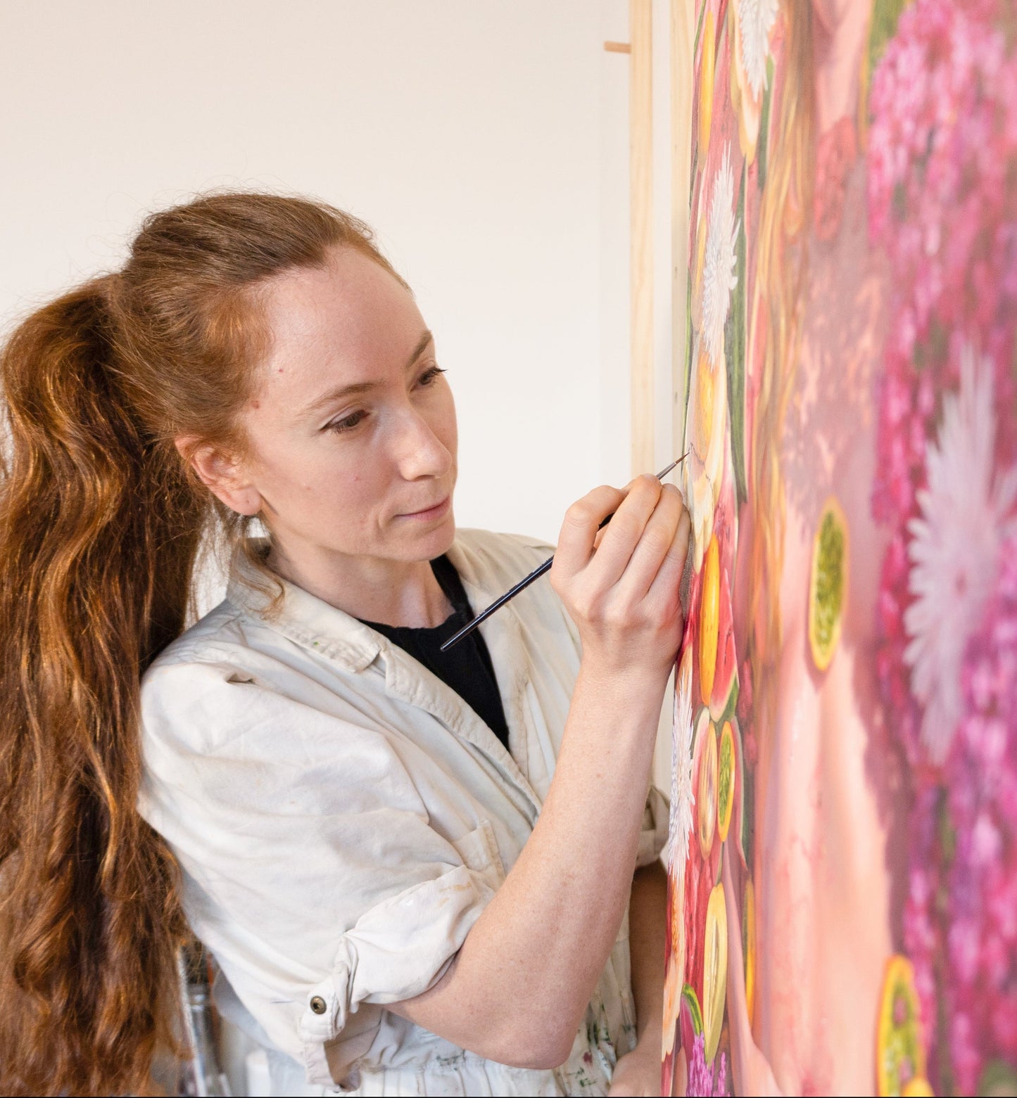 Alonsa Guevara painting a colorful realistic floral scene, showing her skills for her mentorship program.